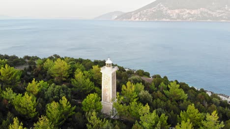 Old-Venetian-Lighthouse-Of-Fiskardo-Surrounded-By-Green-Foliage-With-Overview-Of-Fiskardo-Bay-In-Kefalonia,-Greece