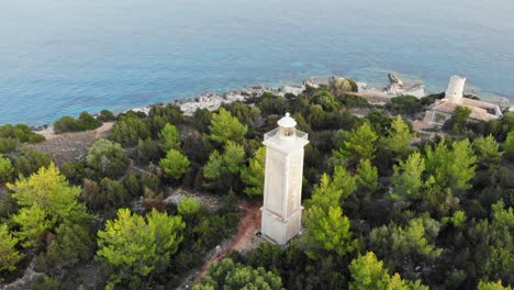Lighthouse-and-Old-Ruined-Lighthouse,-Fiskardo,-Kefalonia-,-Ionian-Islands,-Greece,-Europe---aerial-drone-shot