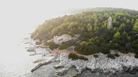 Aerial-View-Of-Two-Lighthouses-With-Dense-Pine-Forest-Near-Fiskardo-Fishing-Village-In-Kefalonia-Island,-Greece
