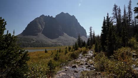 Stunning-nature-landscape-view-of-the-incredible-Red-Castle-Peak-up-a-backpacking-trail-in-the-High-Uinta-National-Forest-between-Utah-and-Wyoming-with-a-small-babbling-brook-and-pine-trees