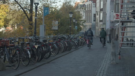 Ciclistas-En-Bicicleta-Por-La-Calle-En-El-Casco-Antiguo-De-Utrecht,-Países-Bajos
