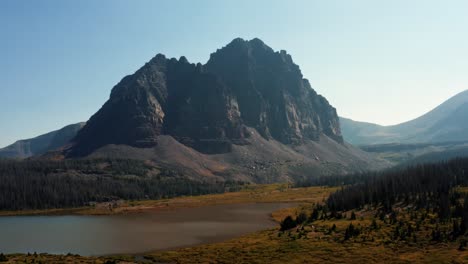 Atemberaubende-Luftdrohnenlandschaft-Natur-Trucking-Linke-Aufnahme-Einer-Großen-Wiese-Mit-Einem-Kleinen-Bach-Mit-Dem-Wunderschönen-Lower-Red-Castle-Lake-Und-Dem-Gipfel-Dahinter-Im-High-Uinta-National-Forest-In-Utah