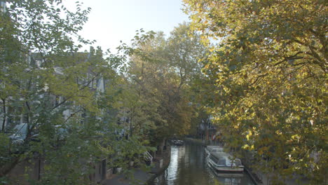 Tilt-down-to-beautiful-canal-with-tour-boats-in-Utrecht-City,-the-Netherlands