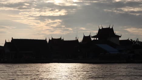 4K-Sillhouette-of-a-Temple-Across-the-River-of-Bang-Tabun-During-a-Morning-Sunrise-in-Thailand