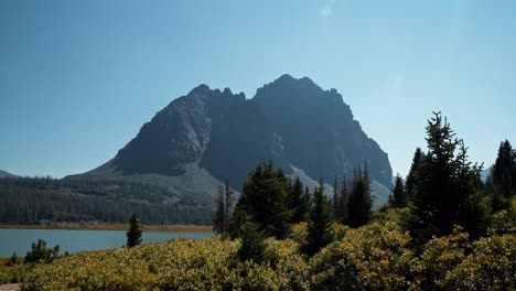 Stunning-nature-landscape-view-of-the-incredible-Red-Castle-Peak-up-a-backpacking-trail-in-the-High-Uinta-National-Forest-between-Utah-and-Wyoming-with-a-fishing-lake-below-and-pine-trees-surrounding