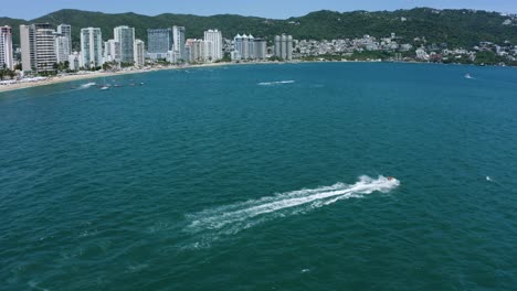 Touristic-Boats-Enjoying-Warm-Summertime-Vacation-in-Tropical-Acapulco-Bay,-Mexico---Aerial