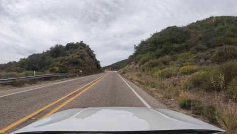 Driving-along-a-country-road-through-rugged-and-rocky-terrain-in-the-Los-Padres-National-Forest---driver-point-of-view