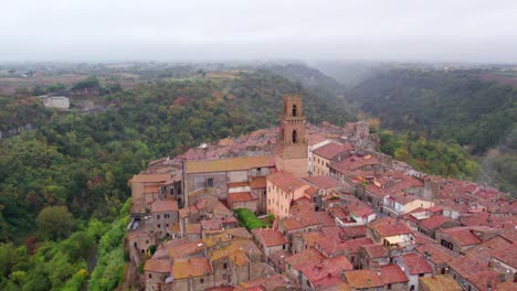 Idyllic-hill-top-town-Pitigliano-with-stone-church-tower,-aerial