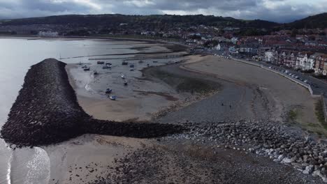 North-Wales-seaside-town-coastline-resort-hotels-harbour-breakwater-aerial-view-orbit-right