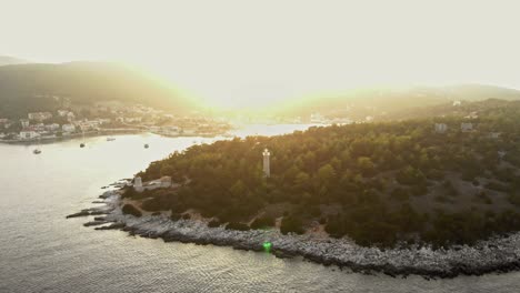 Aerial-View-Of-Fiskardo-Lighthouse-Surrounded-With-Lush-Forest-At-Sunset-In-Kefalonia-Island,-Greece
