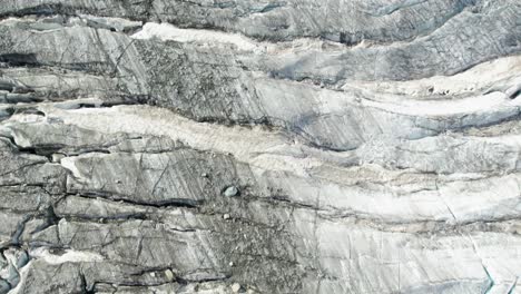 top-down-close-areial-fly-over-ice-glacier-with-deep-black-crevasses-and-cracks,-glacier-melting-concept-of-global-warming,-Aerial-fly-over-of-allalingletscher-switzerland