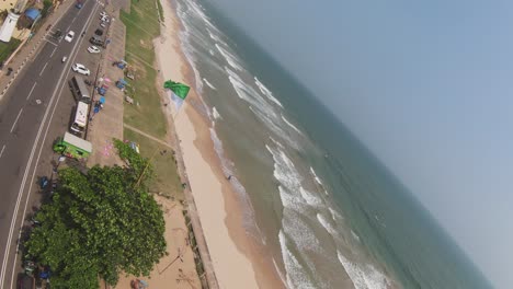 Aerial-Drone-View-Of-Green-And-White-Flag-Flying-In-Wind-Beachside-In-Sri-Lanka-Popular-Tourist-Destination-Mirissa-Beach