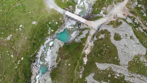 Aufschlussreiche-Luftaufnahme-Des-Türkisblauen-Bergsees-Hoch-Oben-In-Den-Schweizer-Alpen,-Wunderschöne-Berglandschaft-Mit-Blauem-Wasser-Und-Grüner-Landschaft