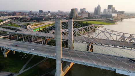 Aerial-view-of-the-Louisville-cityscape-and-bridge,-sunny-evening-in-USA---pan,-drone-shot