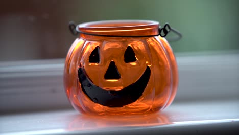 Pumpkin-Halloween-Candle-Sitting-On-A-White-Windowsill