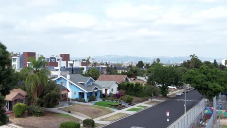 Crenshaw-neighborhood-community-fenced-play-area-homes,-rising-aerial-view-Los-Angeles