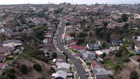 Baldwin-hills-winding-road-through-suburban-residential-neighbourhood-estate-aerial-rising-forward-view