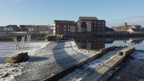 Castleford-Weir-showing-old-working-flour-mill-on-the-bank-of-the-River-Aire-Yorkshire-UK-on-a-bright-sunny-spring-day