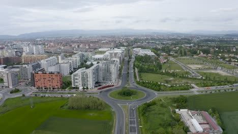 Flying-towards-the-city-across-a-roundabout-from-a-high-angle-on-a-cloudy-day