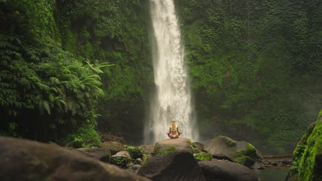 Frau-In-Zen-Sukhasana-Einfache-Pose-Mit-Mächtigem-Wasserrausch-Vom-Nungnung-Wasserfall