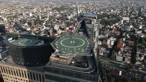 Hochgeschwindigkeitsdrohnenaufnahme-Des-Größten-Hubschrauberlandeplatzes-Von-Mexiko-Stadt,-Panorama-Luftaufnahme-Eines-Turms-Von-Mexiko-Stadt,-Im-Hintergrund-Der-Wald-Von-Chapultepec