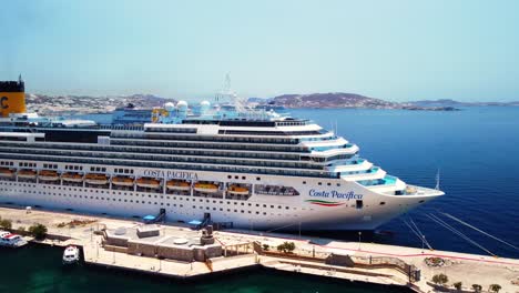 Drone-Aerial-shot-in-Mykonos,-Greece-with-a-cruise-ship-during-holidays-vacation