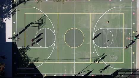 Luftaufnahme-Von-Nachbarschaftskindern,-Die-Zusammen-Basketball-Spielen,-Im-Sommerlichtschatten