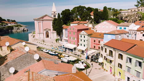 Luftbild-Von-Booten,-Die-Am-Jachthafen-Mit-Hotels,-Restaurants-Und-Kirche-Am-Wasser-In-Veli-Lošinj,-Kroatien,-Festgemacht-Sind