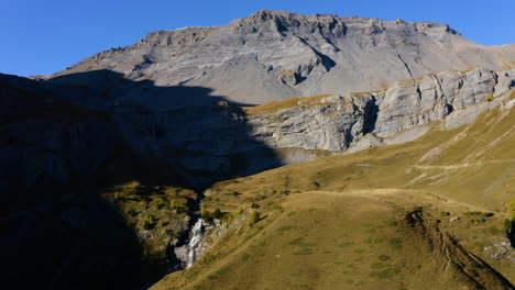 Cascada-Que-Desemboca-En-El-Valle-De-La-Tieche-En-Un-Día-Soleado-Con-La-Cumbre-De-Les-Faverges-Al-Fondo-En-Valais,-Suiza