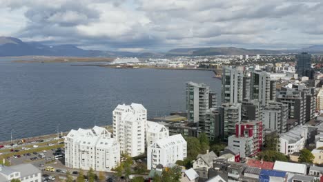 Coastal-area-in-Reykjavik-with-high-rise-apartment-buildings-on-shore,-aerial