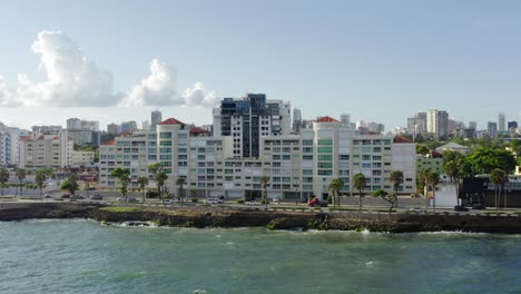 Autoverkehr-Auf-Der-Straße-Entlang-Der-Küste-Von-Malecon-Und-Stadtbild-Im-Hintergrund,-Santo-Domingo