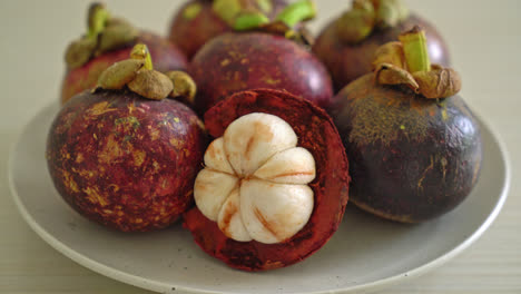 Frutas-Frescas-De-Mangostán-Maduras-En-Un-Plato-Blanco