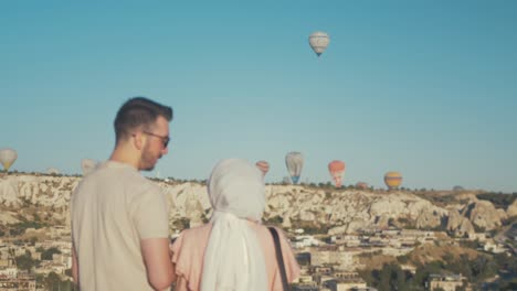 Cute-Turkish-couple-stand-overlooking-Goreme,-Cappadocia