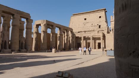 Three-Males-Walking-Across-Courtyard-At-Luxor-Temple