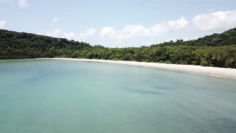 Drone-aerial-over-a-tropical-beach-and-rainforest-moving-forward-and-sideways