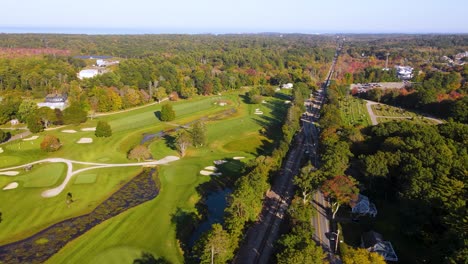 Aerial-sliding-view-of-beautiful-golf-course-amidst-dense-greenery-at-country-club,-Cohasset,-Massachusetts