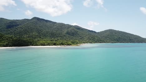 Drone-aerial-parallax-side-ways-over-tropical-blue-ocean-and-Daintree-rainforest