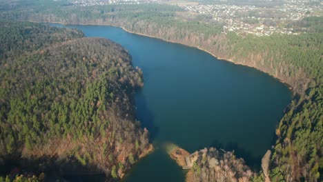 AERIAL:-Lake-Surounded-with-Green-Pine-Forets-During-Chilly-Sunny-Autumn-Day