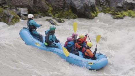 Extreme-paddling-down-powerful-mountain-river,-side-follow-view