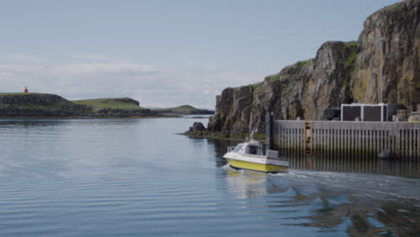 Small-white-and-yellow-boat-sailing-through-Stykkisholmur-in-Iceland
