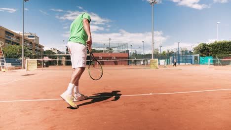 Tennis-player-bounce-ball-in-preparation,-low-angle-slow-motion