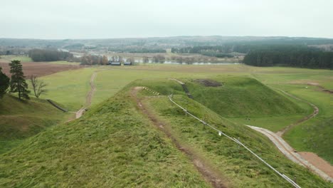 AERIAL:-Flying-off-the-Top-of-Mound-in-Kernave-Archaeological-site,-a-Medieval-Capital-of-the-Grand-Duchy-of-Lithuania