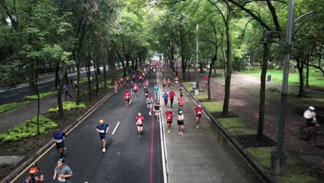 backwards-drone-shot-of-the-runners-of-the-mexico-city-marathon-as-they-run-along-paseo-de-la-reforma-avenue