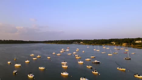 Drone-flight-over-yachts-moored-on-waters-of-island-at-boat-club-during-golden-hour