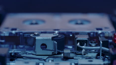Exposed-Internal-Components-Of-Microcassette-Recorder-Playing-Under-Cold-Blue-Lighting
