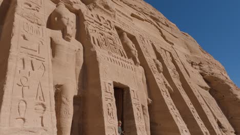 Toma-Panorámica-Hacia-Abajo-De-Un-Turista-Saliendo-Del-Templo-De-Abu-Simbel