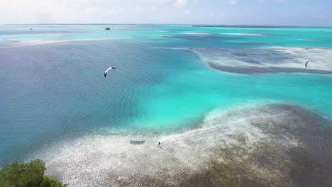 Aerial-view-tracking-Man-kiteboard-FLYING-IN-NATIONAL-PARK-LOS-ROQUES