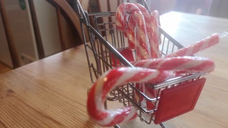 Small-shopping-trolley-filled-with-Christmas-candy-canes-home-delivery-concept-kitchen-idea-dolly-left