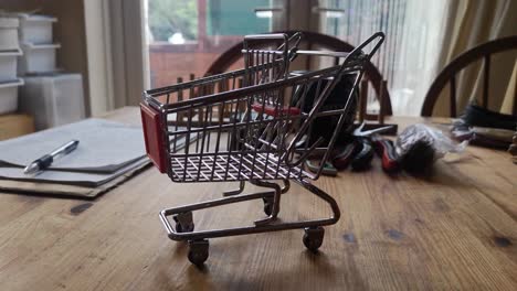 Small-shopping-trolley-online-home-business-concept-on-kitchen-table-copy-space-closeup-left-dolly-shot