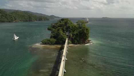 Aerial-orbit-shot-of-famous-Samana-Bay-with-docking-Boat-and-Cruise-Ship-in-background---Beautiful-sunny-day-with-pedestrian-crossing-bridge-to-rural-island,Dominican-Republic